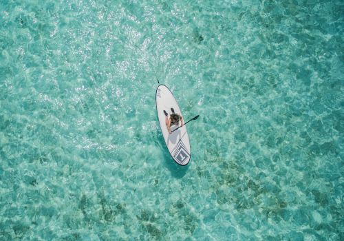 Person paddling in middle of sea